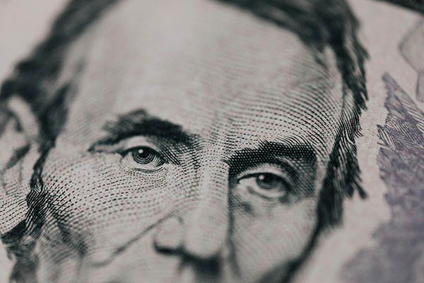 Image of a close-up of a five dollar bill.